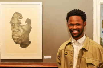 The Portrait Awards Winner 2025 Malik Mani with his work, "Mask", pencil on paper.