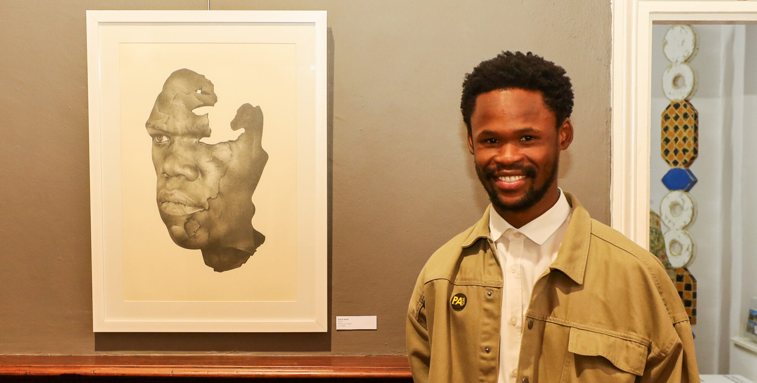 The Portrait Awards Winner 2025 Malik Mani with his work, "Mask", pencil on paper.